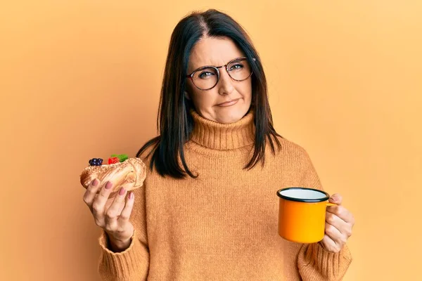 Mulher Morena Meia Idade Comendo Pastelaria Bebendo Café Rosto Choque — Fotografia de Stock