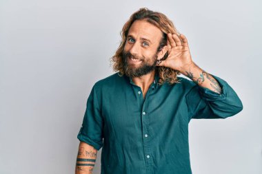 Sakallı, uzun saçlı, günlük kıyafetler giyen, sırıtan, kulağına fısıldayan dedikoduları ve dedikoduları dinleyen yakışıklı bir adam. Sağırlık kavramı. 