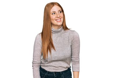 Sıradan kıyafetler giyen genç İrlandalı kadın yüzünde gülümsemeyle yan yana bakıyor, doğal bir ifade. Kendinden emin gülen. 