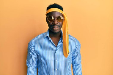 Yakışıklı, sarhoş, kafasına kravat takmış, güneş gözlüğü takmış, yüzünde mutlu ve havalı bir gülümseme vardı. şanslı kişi. 