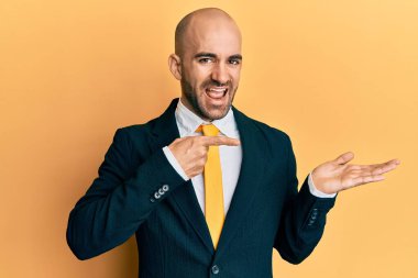 Genç İspanyol adam iş elbisesi giyiyor ve kravat takıyor kameraya hayret ediyor ve gülümsüyor.. 