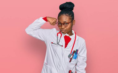 Genç Afro-Amerikan kadın doktor üniforması ve steteskop giyen güçlü kol kası olan, kendinden emin ve gururlu biri. 