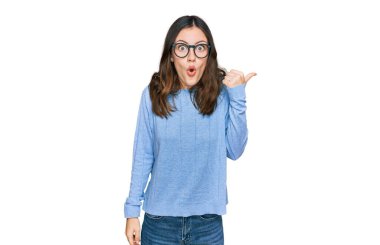 Gündelik giysiler ve gözlük takan genç ve güzel bir kadın el ile işaret ederek şaşırdı, ağzı açık hayret içinde kaldı.. 