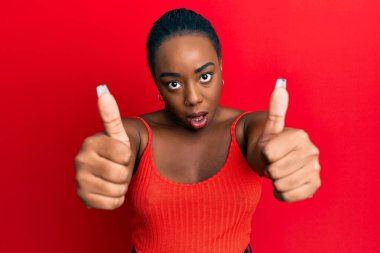 Afro-Amerikalı genç bir kadın şok olmuş yüzüne olumlu bir jest yapıyor. Şüpheci ve alaycı bakıyor. 