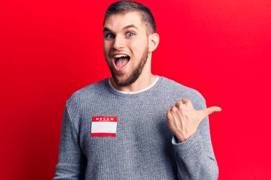 Merhaba giyen genç yakışıklı adam benim adım çıkartma başparmağımı yukarı kaldırıyorum mutlu bir şekilde gülümsüyorum. 