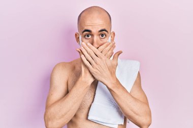 Genç, kel, sakalsız, köpüklü sakallı, ağzı kazara ellerle kapatan bir adam. gizli kavram. 