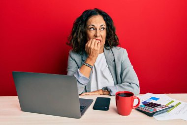 Ofiste çalışan orta yaşlı güzel bir kadın. Bir fincan kahve içiyor. Gergin ve gergin görünüyor. anksiyete. 
