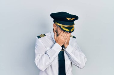 Genç İspanyol pilot üniforması giyiyor. Ağlarken yüzünü ellerle kapatıyor. depresyon kavramı. 