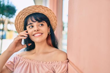 Yaz stili giyinmiş genç İspanyol turist kız şehirde akıllı telefondan konuşuyor..