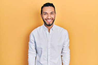 Sakallı, iş gömleği giyen mutlu ve havalı bir gülümsemesi olan İspanyol bir adam. şanslı kişi. 