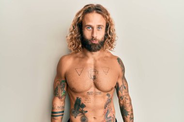 Sakallı, uzun saçlı, dövmeleri olmayan, üzgün ve üzüntülü, sinirli ve korkmuş bir adam. hüzünlü ifade. 