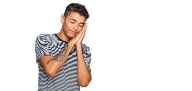 Genç, yakışıklı, Afro-Amerikalı, günlük kıyafetler giymiş, yorgun uyuyor, hayal kuruyor ve elleri ile poz veriyor, gözleri kapalı gülümsüyor.. 