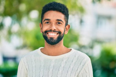 Genç Afrikalı Amerikalı adam parkta mutlu bir şekilde dikiliyor..