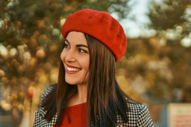 Genç İspanyol kadın gülümseyerek şehirde mutlu mesut dikiliyor..