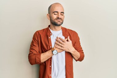 Gündelik kıyafetler giyen genç İspanyol adam elleri göğsünde gülümsüyor, gözleri kapalı ve yüzünde minnet ifadesi var. sağlık kavramı. 