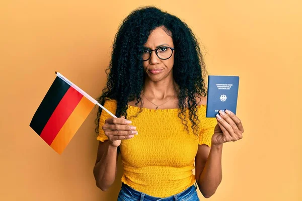 Mujer Afroamericana Mediana Edad Con Bandera Alemania Pasaporte Escéptico Nervioso —  Fotos de Stock
