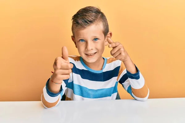 Adorable Caucasian Kid Wearing Casual Clothes Sitting Table Pointing Fingers — Stock Photo, Image