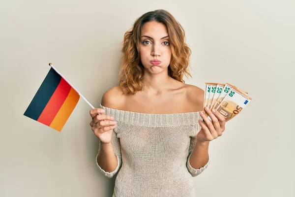 Ung Kaukasisk Kvinna Som Håller Tyska Flagga Och Eurosedlar Puffande — Stockfoto