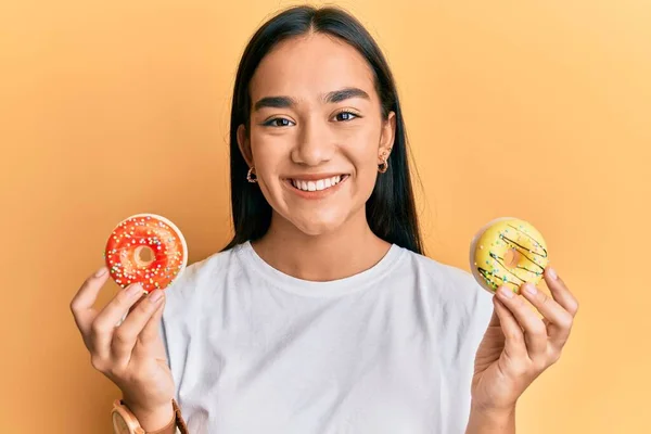 Mujer Asiática Joven Sosteniendo Sabrosas Rosquillas Coloridas Sonriendo Con Una —  Fotos de Stock