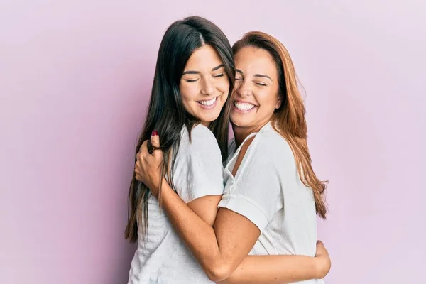 Mooie Latino Moeder Dochter Glimlachen Gelukkig Knuffelen Geïsoleerde Roze Achtergrond — Stockfoto