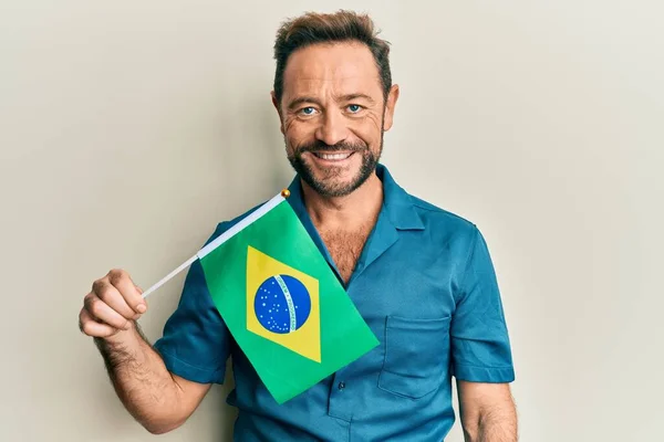 Muž Středního Věku Držící Brazilskou Vlajku Vypadá Pozitivně Šťastně Stojící — Stock fotografie