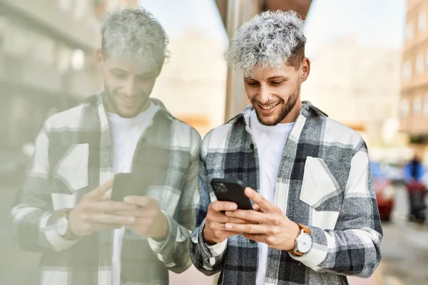 Joven Hombre Hispano Sonriendo Feliz Usando Smartphone Ciudad —  Fotos de Stock