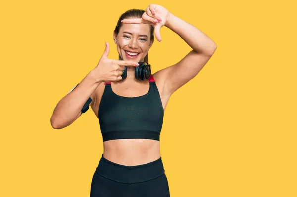 Güzel Sarışın Kadın Spor Kıyafetleri Giyiyor Kulaklık Takıyor Gülümsüyor Elleri — Stok fotoğraf