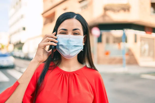Νεαρή Λατίνα Που Φοράει Ιατρική Μάσκα Και Μιλάει Στο Smartphone — Φωτογραφία Αρχείου