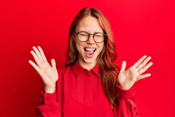 Jonge Mooie Roodharige Vrouw Draagt Casual Kleding Glazen Rode Achtergrond — Stockfoto