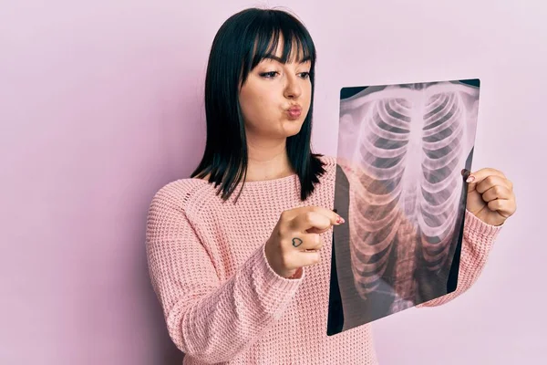 胸のX線を持っている若いヒスパニック系の女性は面白い顔で頬をパフ 空気を吸い込み空気を吸い込み — ストック写真