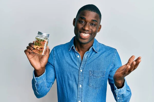 Joven Hombre Afroamericano Sosteniendo Tarro Con Pasta Farfalle Celebrando Logro — Foto de Stock