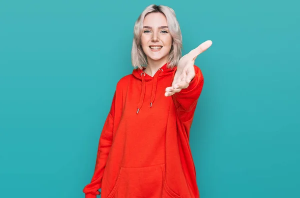 Ung Blondine Pige Iført Afslappet Tøj Smilende Venlige Tilbyder Håndtryk - Stock-foto