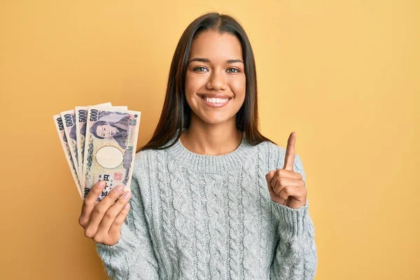 Krásná Hispánská Žena Držící 5000 Japonských Jenových Bankovek Usmívající Myšlenkou — Stock fotografie