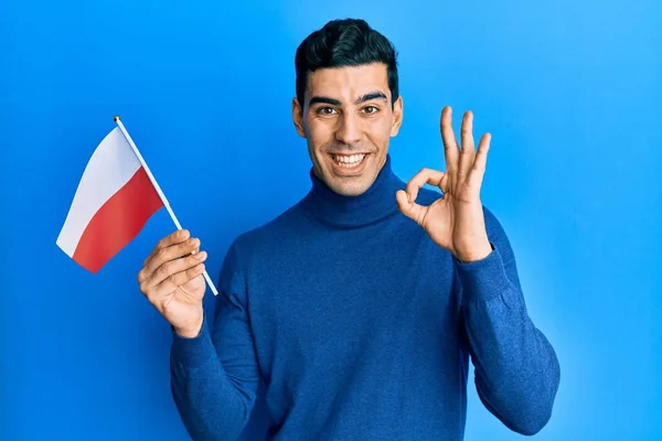 Bonito Homem Hispânico Segurando Bandeira Polônia Fazendo Sinal Com Dedos — Fotografia de Stock