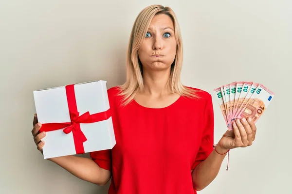 Middle Age Caucasian Woman Holding Gift Euros Banknotes Puffing Cheeks — Stock Photo, Image