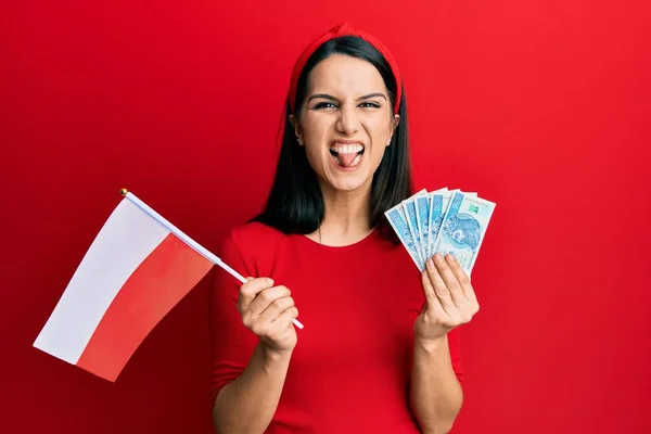 Young Hispanic Woman Holding Poland Flag Zloty Banknotes Sticking Tongue — 图库照片