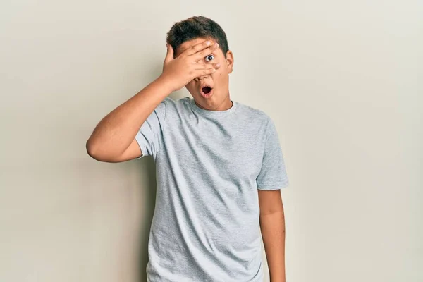 Adolescente Hispano Vistiendo Casual Camiseta Gris Asomándose Shock Cubriendo Cara — Foto de Stock
