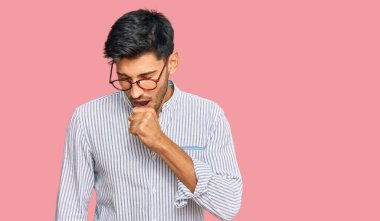 Sıradan kıyafetler ve gözlük takan yakışıklı genç adam kendini iyi hissetmiyor ve soğuk algınlığı veya bronşitin belirtisi olarak öksürüyor. sağlık hizmeti kavramı. 