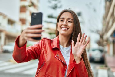 Genç İspanyol kadın şehirde akıllı telefon kullanarak video görüşmesi yapıyor..