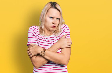 Kafkasyalı genç bir kadın günlük kıyafetler giyiyor. Kış soğuğu için titriyor ve donuyor. Yüzünde üzgün ve şok ifadesi var. 