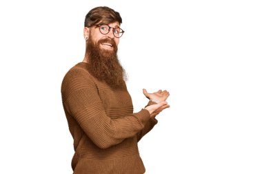 Genç İrlandalı kızıl elbiseli ve gözlüklü adam gülümseyerek içeri girmeye davet ediyor. 