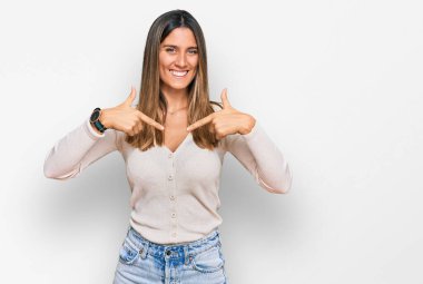 Gündelik kıyafetler giyen, kendine güveni olan, kendini gururlu ve mutlu gösteren genç bir kadın.. 