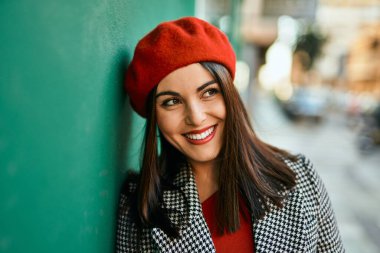 Genç İspanyol kadın gülümseyerek şehirde mutlu mesut dikiliyor..