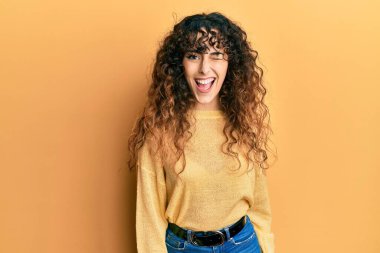 Gündelik kıyafetler giyen genç İspanyol kız kameraya seksi bir ifadeyle bakıyor, neşeli ve mutlu bir yüzle.. 