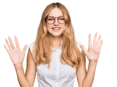 Beautiful young caucasian girl wearing casual clothes and glasses showing and pointing up with fingers number ten while smiling confident and happy.  clipart