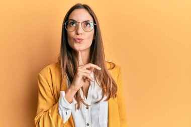 İş stili ve gözlük takan genç ve güzel bir kadın şüpheye odaklanmıştı. Parmakları çenesinde ve yukarı bakıyordu. 