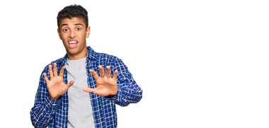 Genç, yakışıklı, Afro-Amerikan bir adam günlük kıyafetler giyiyor. Korkudan dehşete düşmüş ve korkmuş bir ifade. El hareketlerini durdur, şok içinde bağır. panik konsepti. 