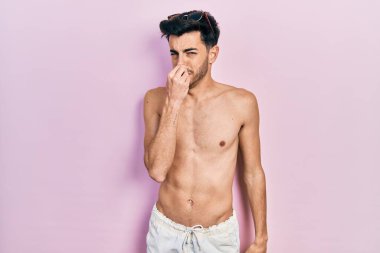 İspanyol asıllı genç adam mayo giyiyor. Kokuşmuş ve iğrenç bir koku alıyor. Dayanılmaz bir koku. Kötü kokuyor. 