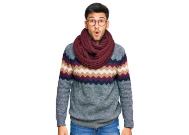 Kış süveteri giyen genç ve yakışıklı bir adam. Korkmuş ve ağzı açık kalmış, şaşırmış ve şaşırmış. 