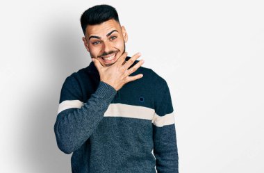 Sakallı, sıradan bir kazak giyen genç İspanyol adam kameraya kollarını kavuşturup gülümseyerek ve çenesini kaldırarak bakıyor. Olumlu düşünmek. 